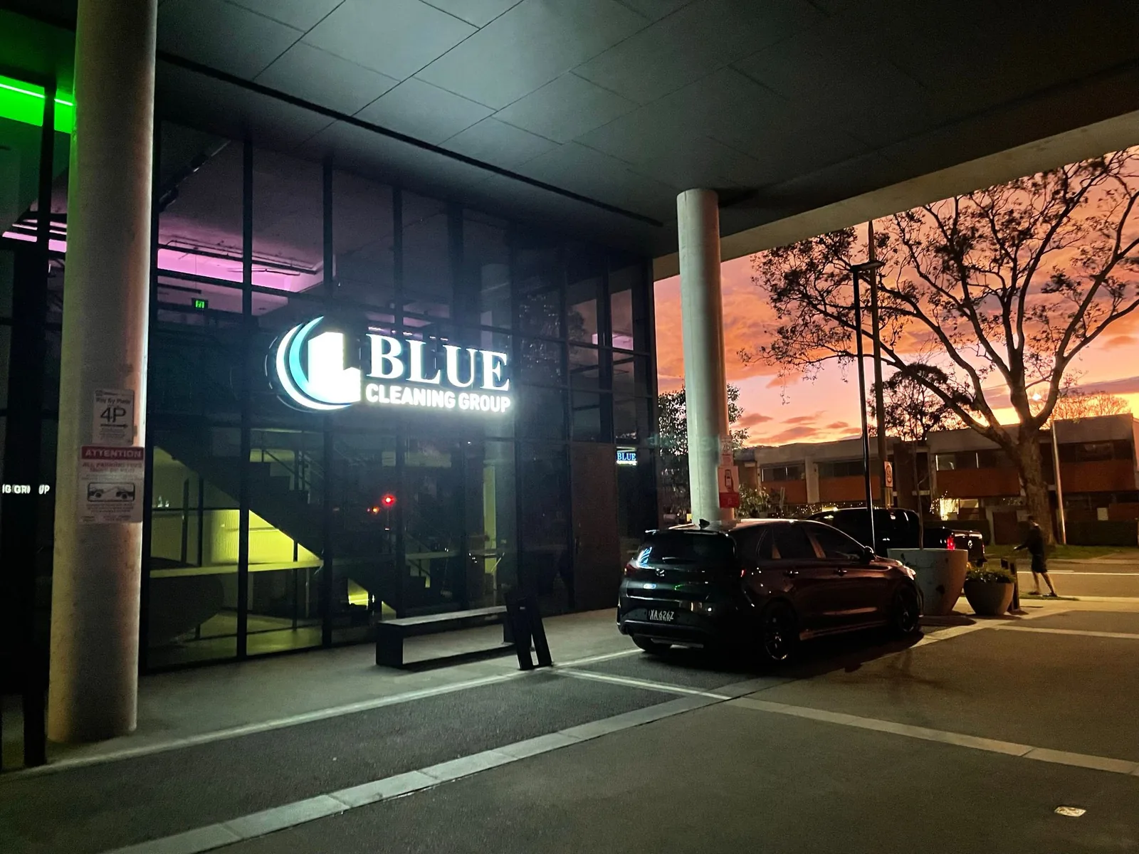 The Blue Cleaning Group sign lit on the glazing of our office at dusk